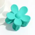 Close up of turquoise matte flower hair claw clip, delicate floral design for women hair styling. - Emerald