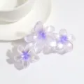 Primo piano dettagliato di una molletta per capelli a triplo fiore sfumato viola perlato. - Viola