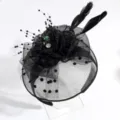 Detail shot of elegant black mesh fascinator headband with feathers and crystal accents. - Black Flower Veil