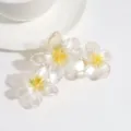 Primer plano detallado de la pinza para el cabello con tres flores y degradado transparente. - Amarillo