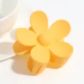 Primer plano de pinza de pelo de flor mate amarilla, detalle de accesorio macaron. - Hojas amarillas