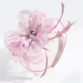 Detailed view of the pink feather fascinator headband with mesh, pearls, and delicate floral design. - Purple Veil Feather