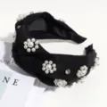 Primer plano detallado de la diadema negra con nudo, decorada con perlas elegantes y pedrería brillante. - Negro