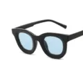 Trendy zonnebril met dik zwart montuur en lichtblauwe glazen voor een stijlvolle look. - Zwart montuur blauwe glazen