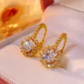 Close-up detail of luxurious round moissanite halo earrings with sparkling stones and gold tone. - Moissanite (B009B1000Y00) / 1 ct / Gold