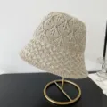 Nahaufnahme des beigen Strick-Eimerhuts mit dem hohlen Mesh-Rautenmuster für den Sommer. - M (56-58cm) / Beige