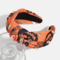 Close-up of Halloween knotted headband with rhinestones, pumpkin and spiderweb patterns. - Orange Spider Web