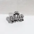 Detailaufnahme einer silbernen metallischen Wellen-Haarklammer, elegantes Haaraccessoire. - Wellendunkelgrau
