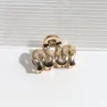 Detailansicht der goldenen Metall Haarklammer, stilvolles abstraktes Wellen-Design, Haarschmuck - Wellenorangegold