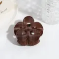 Gros plan détail de la pince à cheveux fleur en velours à carreaux marron avec texture douce. - Brun Ajouré