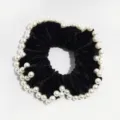 Black velvet hair scrunchie detail shot featuring elegant faux pearls along the edge, chic. - Black