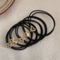 Ensemble d'élastiques noirs avec breloques en métal doré comme des étoiles, nœuds et cœurs. - Style Pendentif Couronne de Fleurs / Set de 5 pièces / Noir