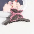 Primo piano di una pinza per capelli a farfalla opaca in grigio scuro e rosa, elegante. - Stile Farfalla / Caffè