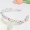 Close-up of transparent rhinestone floral hair hoop, candy color detail for sweet styles. - Snowflake Candy Color