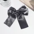 Close-up detail of the elegant dark grey satin bow hair clip, showcasing smooth fabric. - Dark Gray