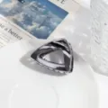 Gedetailleerd overzicht van de zilveren metalen driehoekige haarklem met modern geometrisch design. - Donkergrijze Driehoek