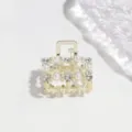 Vista dettagliata di un piccolo fermaglio per capelli dorato con perle e strass luminosi. - 3cm / Quadrato Perla Strass