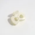 Close-up detail of a cream bow hair claw clip with silver speckles for styling. - Bow / White