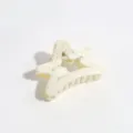 Close-up of a cream white star-shaped hair claw clip featuring stylish silver splatter design. - Star / White