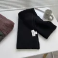 Nahaufnahme des schwarzen Strickschals Detail mit gerippter Textur und Etikett auf Tisch. - 180cm / Klassisches Schwarz