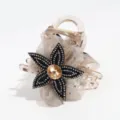 Close-up details of the elegant mesh flower hair claw clip with shiny rhinestones. - Brown