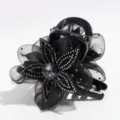 Close-up detail of black mesh flower hair claw clip featuring sparkling rhinestones and crystal. - Black
