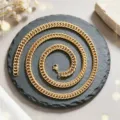 Gros plan d'un collier chaîne gourmette en acier inoxydable doré sur ardoise noire - Chaîne Gourmette Or (XL2002-33) / 1.6mm Double Anneau x 60cm