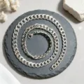 Gros plan d'un collier à maillons cubains en acier inoxydable sur une base en pierre. - Chaîne Gourmette Épaisse Argent (XL2002-36) / 9mm Large x 60cm