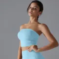 A close-up detail shot of a light blue ruched strapless yoga tube top worn by a model - S / Tops / Sky Blue
