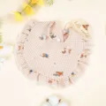 Dettaglio del bavaglino per neonati in cotone vichy beige con volant e stampe di animali. - Cucciolo a Quadri