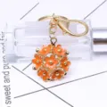 Schlüsselanhänger mit orangefarbenem Gänseblümchenball und goldenem Verschluss - Orange