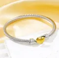 Brazalete rígido de cable trenzado de acero inoxidable con dije de corazón de oro 18k - 126 Bicolor