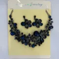 Vista dettagliata di un set di gioielli vintage in metallo nero con fiori blu - Nero