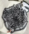 Dettaglio di un elegante foulard in seta leopardato con un raffinato bordo nero di design - Leopardo Grigio