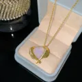 Elegant gold titanium steel necklace featuring a pink crystal heart pendant with wings. - Pink Heart Style (YMW569) / Gold-Pink Heart Necklace