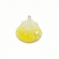 Detailed close-up of a yellow gradient resin shell charm with glitter, tiny star, and pearls. - Yellow