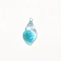 Gros plan sur le pendentif coquillage bleu transparent, détail accessoire bijou DIY brillant. - Bleu