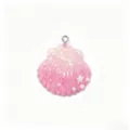 Detailed close-up of a pink gradient resin shell charm with glitter, star and pearl accents. - Pink