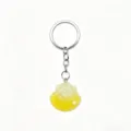 Closeup of the glitter shell pendant detail on the keychain, showing fine texture and shiny finish. - Yellow