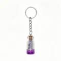 Detailed view of ocean theme wishing bottle keychain with purple sand and cute miniature charm. - Purple