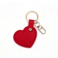 Red heart-shaped leather keychain detail showing exquisite stitching and golden ring hardware. - Red