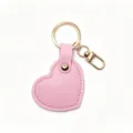 Pink heart leather keychain bag charm, detailed close-up of gold metal ring and hardware. - Pink