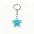 Close-up of sparkling blue resin starfish keychain pendant with silver metal ring. - Blue