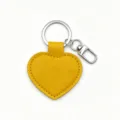 Yellow PU leather heart keychain detail shot, showing smooth surface and metal clasp. - Yellow