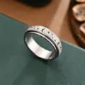 Nahaufnahme des Edelstahl-Drehrings mit matter Textur sowie feinen Sternen und Mondmotiven. - Größe 6 / Stahlfarben