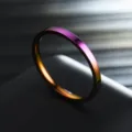 Close-up of a slim 2mm rainbow stainless steel ring showing vibrant metallic gradient shine. - Size 5 / Colorful