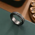 Closeup detail of stainless steel rotating ring featuring frosted star and moon pattern. - Black