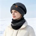 Close-up of a women's winter knitted beanie and neck warmer set in a snowy landscape - One Size / Set / Black