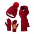 Detail view of a dark red winter set with knitted pom-pom hat, scarf, and warm gloves. - Red