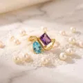 Detailed shot of a luxury gold-plated ring featuring purple and blue gemstones on pearls. - Size 5 / Birthstone - February